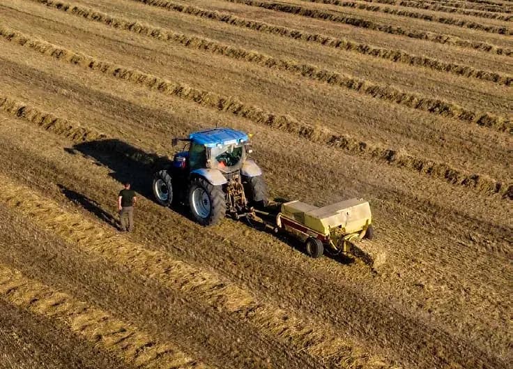 Prasa kostkująca formuje belę słomy na polu — szpagat, siatka i folia Cotesi do belowania i pakowania